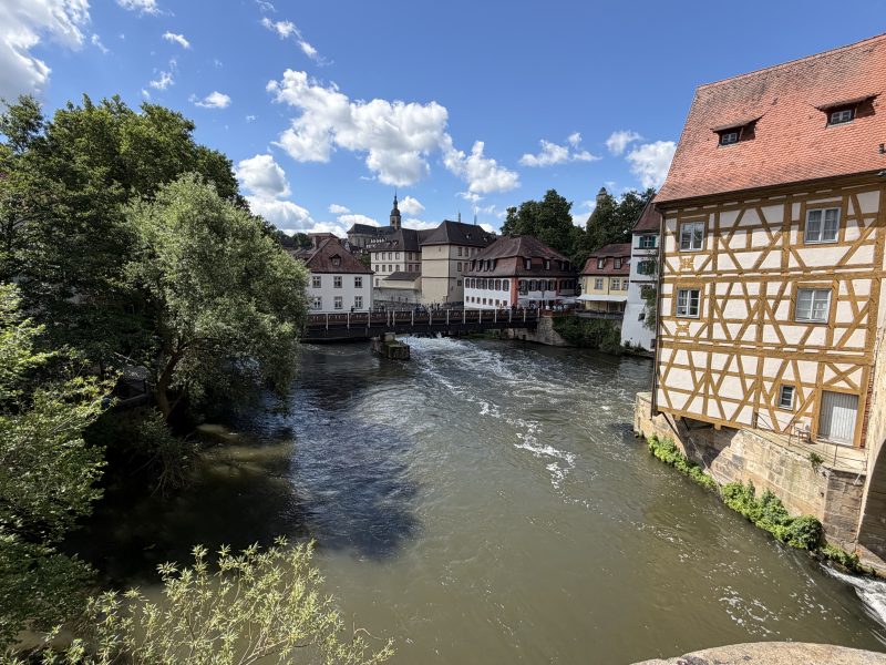 Flusslauf zwischen Fachwerkhaus und Altstadthäusern.